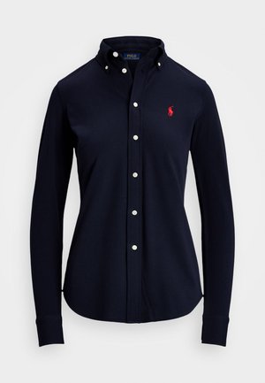 Granatowa koszula z długim rękawem, zapinana na guziki, z kołnierzykiem zapinanym na guziki oraz czerwonym, haftowanym logo Polo Ralph Lauren na lewej piersi.
