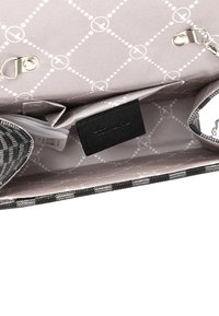 Cartera de tela a rayas en blanco y negro con forro gris que presenta un patrón geométrico, cierre de cremallera y una etiqueta negra en el interior.