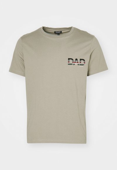 T-shirt de algodão verde-azeitona com decote redondo e mangas curtas; apresenta a palavra "DAD" em preto e branco com detalhes às riscas no peito.