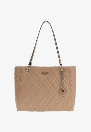 Sac cabas beige matelassé avec deux poignées, détail de logo doré, et chaîne décorative avec breloque. Texture lisse et forme structurée.