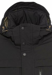 Black insulated jacket with a high collar, quilted interior, and gold-accented drawstrings. Features snap closures and a zippered pocket.