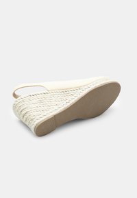 Sandal s klinastim peto iz bež platna, slingback zasnova ter platforma ovita z juto. Teksturalna gumijasta podloga za oprijem.