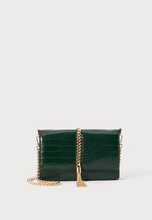 Green crocodile-embossed leather handbag with a gold chain strap and a tassel accent. Features a rectangular shape and glossy finish.