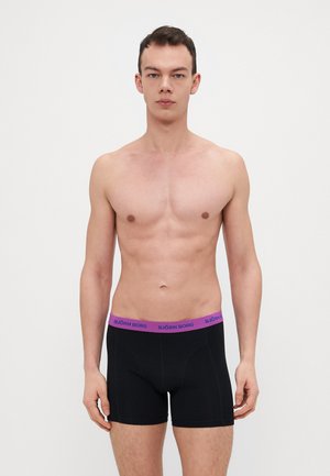 Svarte boksershorts med lilla midjebåndet som har "BJÖRN BORG"-logoer; glatt tekstur og tettsittende design for komfort.