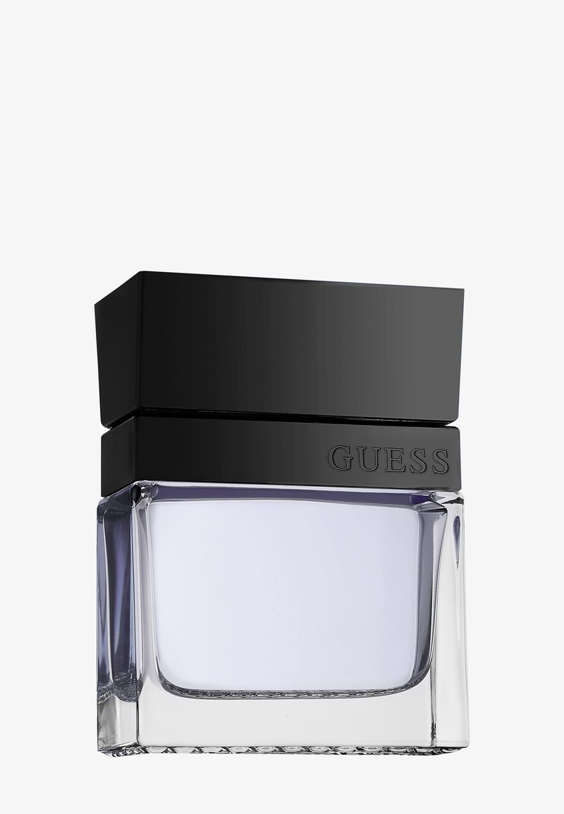 Klares Glasparfümfläschchen mit hellvioletter Flüssigkeit, großem schwarzem rechteckigem Deckel und "GUESS" auf einem schwarzen Band unter dem Deckel geprägt.