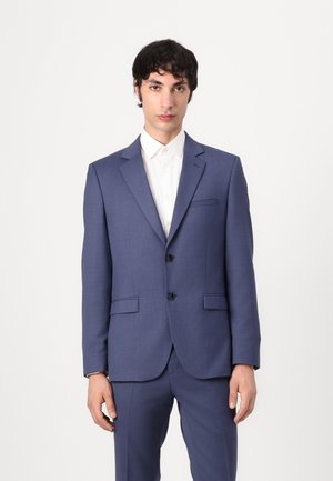 Marineblå dress med en skreddersydd passform, som har to knapper, notched lapels og sidelommer, sammen med en hvit skjorte med krage.