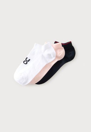 Trois paires de chaussettes basses en blanc avec logo noir, rose clair et noir avec bordure rouge, disposées en chevauchement sur un fond clair.