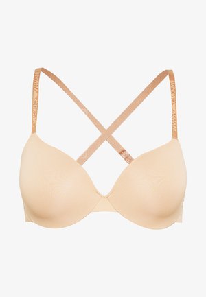 Beige padded bra with a smooth texture, featuring crisscross straps and a branded metallic strap along the back.