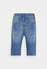 Pantalones cortos de mezclilla en azul medio, con corte recto, dos bolsillos traseros y un acento de cuero marrón en la cinturilla.