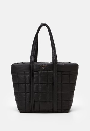 Sac cabas matelassé noir avec poignées rembourrées et logo Michael Kors doré centré près du haut.