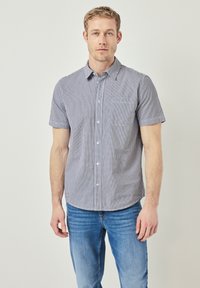 Kortärmad rutigt skjorta i blått och vitt med button-down krage, framficka och slim fit, parat med blå denimjeans.