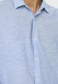 Camicetta azzurra a maniche corte realizzata in tessuto intrecciato. Presenta un davanti con bottoni, una consistenza morbida e un design del colletto classico.