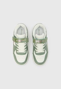 Πράσινα και λευκά αθλητικά παπούτσια με λαστιχένια σόλα, διαθέτουν λουράκι με βέλκρο και κορδόνια. Κατασκευασμένα από λείο δέρμα και διχτυωτό υλικό με διάτρητη μύτη.