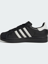 Čierna kožená teniska s bielymi textúrovanými tromi pásikmi, zaoblenou špičkou a čiernou podrážkou. Má šnurovanie vpredu a výrazný dizajn špičky.