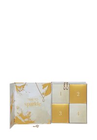 Adventskalender met vier gouden en crèmekleurige genummerde doosjes, parelsieraden tentoongesteld op de deksels van de doosjes, en de tekst "Tijd om te schitteren" aan de linkerkant.