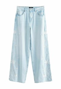 Lichtblauwe flared jeans van denim, met ingewikkelde witte bloemborduursels aan de buitenzijde. Sluiting met knoop en rits.