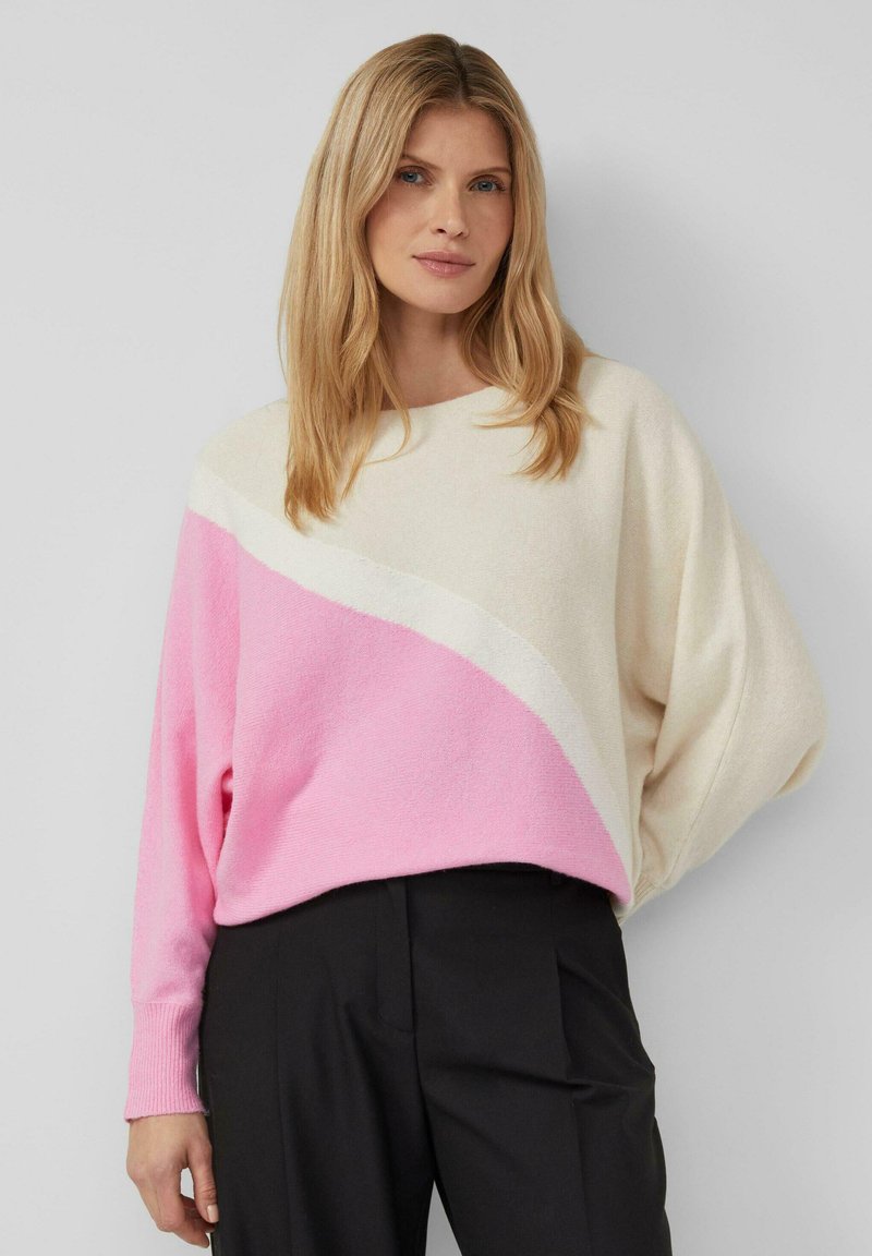 Pull léger à blocs de couleur en crème et rose, présentant un motif diagonal. Col rond, coupe ample, avec des manches longues. Texture tricotée.
