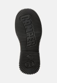 Svart gummisula med ribbad struktur, präglad "CAMPER"-logotyp, storlek "38", och en rundad design med distinkta mönsterlinjer.