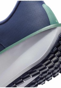 Scarpa da ginnastica in mesh blu navy con accento verde, intersuola bianca liscia e suola esterna nera testurizzata con motivo a diamante.