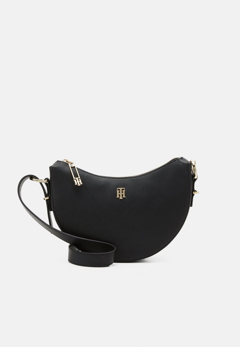 Sac bandoulière en cuir noir en forme de demi-lune, avec une fermeture éclair dorée et un logo, ainsi qu'une sangle réglable. Surface texturée.
