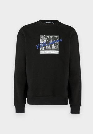 Sudadera negra con una imagen gráfica en el frente que muestra una foto en blanco y negro y texto azul. Tela suave, cuello redondo y puños acanalados.