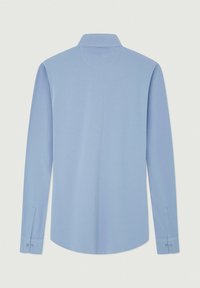 Camicia azzurro chiaro a maniche lunghe con colletto classico, caratterizzata da una texture liscia e polsini con bottoni, mostrata di spalle.