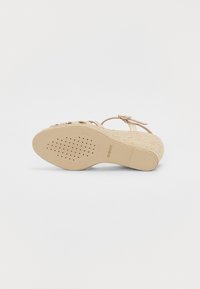 Sandale compensée beige avec talon espadrille tissé, bride à la cheville et semelle perforée pour la respirabilité, marque Geox.