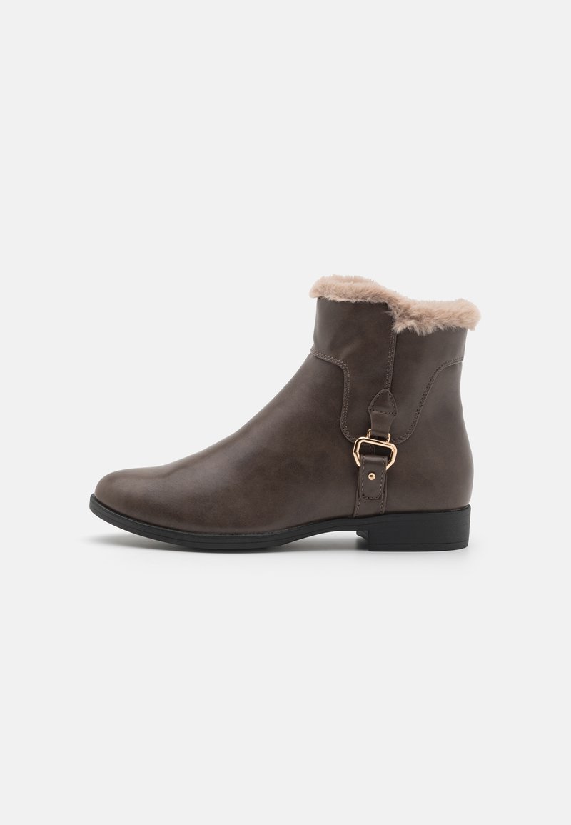 Botte de cheville en faux cuir brun avec une douce garniture en fourrure beige, accent en boucle, bout rond et petit talon noir. Texture lisse et design épuré.