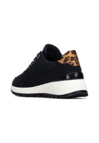 Zapatilla negra con parte superior texturizada y acento de estampado de leopardo en el talón. Cuenta con una media suela blanca y suela de goma negra para mayor agarre.