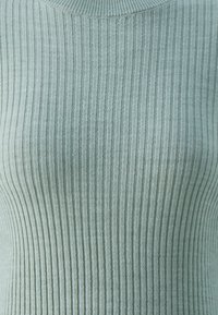 Helles grünes geripptes Sweatshirt mit einer weichen Textur und einer taillierten Passform. Verfügt über vertikale Streifen und einen runden Ausschnitt.