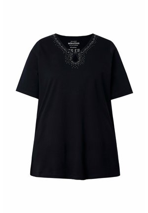 Maglietta nera a maniche corte con scollo rotondo, decorata con piccoli borchietti argentati e un intaglio a forma di goccia al centro davanti.