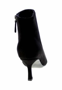 Stivale alla caviglia in suede nero con punta appuntita, tacco stiletto sottile e zip laterale. Texture liscia, design elegante.