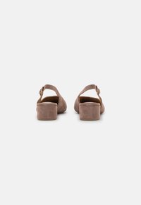 Tacchi in suede rosa con tacco a blocco, schiena aperta e cinturino alla caviglia regolabile. Tessuto liscio con finitura opaca.