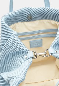 Borsa a tracolla blu chiaro con esterno intrecciato, interno con foderatura beige, tasca con zip e etichetta con marchio. Componenti in argento sulla tracolla.