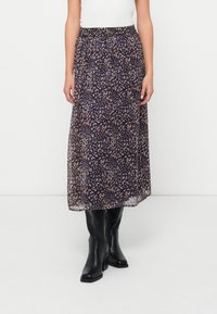 Maxi nederdel i et mørkt stof med et blomstermønster i nuancer af brun og lilla. Elastisk talje og lagdelt, gennemsigtig design. Sorte knæstøvler.