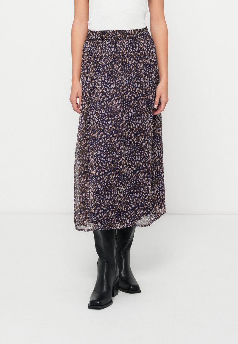 Maxi nederdel i et mørkt stof med et blomstermønster i nuancer af brun og lilla. Elastisk talje og lagdelt, gennemsigtig design. Sorte knæstøvler.