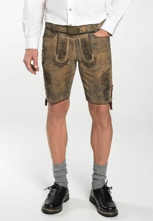 Bayerische Lederhosen aus braunem Leder, verziert mit floralen Stickereien, einem Gürtel und seitlichen Schnürungen, getragen mit grauen Socken und schwarzen Schuhen.