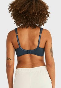 Donkerblauwe beha met brede banden, kantaccenten en een haak-en-oogsluiting op de rug. Gladde stof met een getailleerde pasvorm.