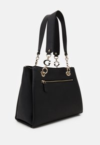 Musta nahkalaukku, jossa on kultainen vetoketjupussi, kaksinkertaiset yläkahvat ja kultaiset logokorut valkoista taustaa vasten.