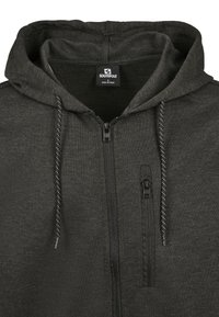 Felpa con zip grigio scuro, dotata di cappuccio regolabile con cordini, tasca con zip sul petto e etichetta del marchio Southpole all'interno del colletto.