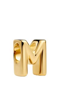 Bague dorée en forme de lettre "M", avec une surface lisse et brillante, des bords arrondis et une ouverture circulaire.