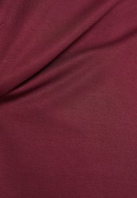 Bordeauxfarbener Stoff mit glatter Textur und leichtem Glanz, ausgestattet mit einem diagonalen Rippmuster, das mit sanften Falten drapiert ist.