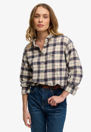 Flanellen shirt met een geruit patroon in roomkleur, marineblauw en bordeauxrood; heeft een knoopsluiting kraag en een geborduurd logo op de borst.