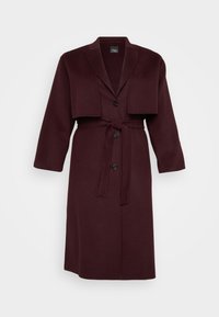 Burgundy wool blend coat with a notched lapel, cropped jacket overlay, two buttons, and a matching tie belt. Long sleeves, mid-length.