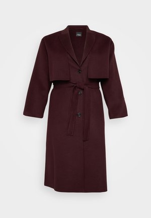 Cappotto in misto lana color bordeaux con revers, sovrapposizione di giacca corta, due bottoni e cintura abbinata. Maniche lunghe, lunghezza media.