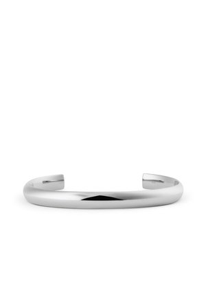 Eenvoudige gepolijste zilveren manchetarmband met een glad, afgerond oppervlak en open uiteinden tegen een witte achtergrond.