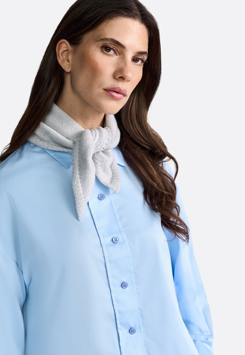 Light blue, long-sleeve button-up shirt with a smooth texture. A light gray knit scarf tied at the neck adds layered detail.