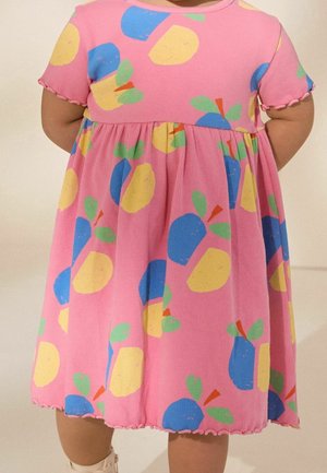Lyserød ribstrikket kjole med farverige frugtmønstre i gult, blåt og grønt. Korte ærmer med flæsekant; design med samlet talje.