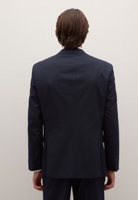 Dark navy suit jacket with a tailored fit, single-breasted design, subtle pinstripe pattern, and two-button front closure.
