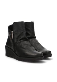 Botas de piel negra hasta el tobillo con un acabado texturizado, tacón en cuña y detalle de cremallera lateral. Construcción suave para un movimiento flexible.